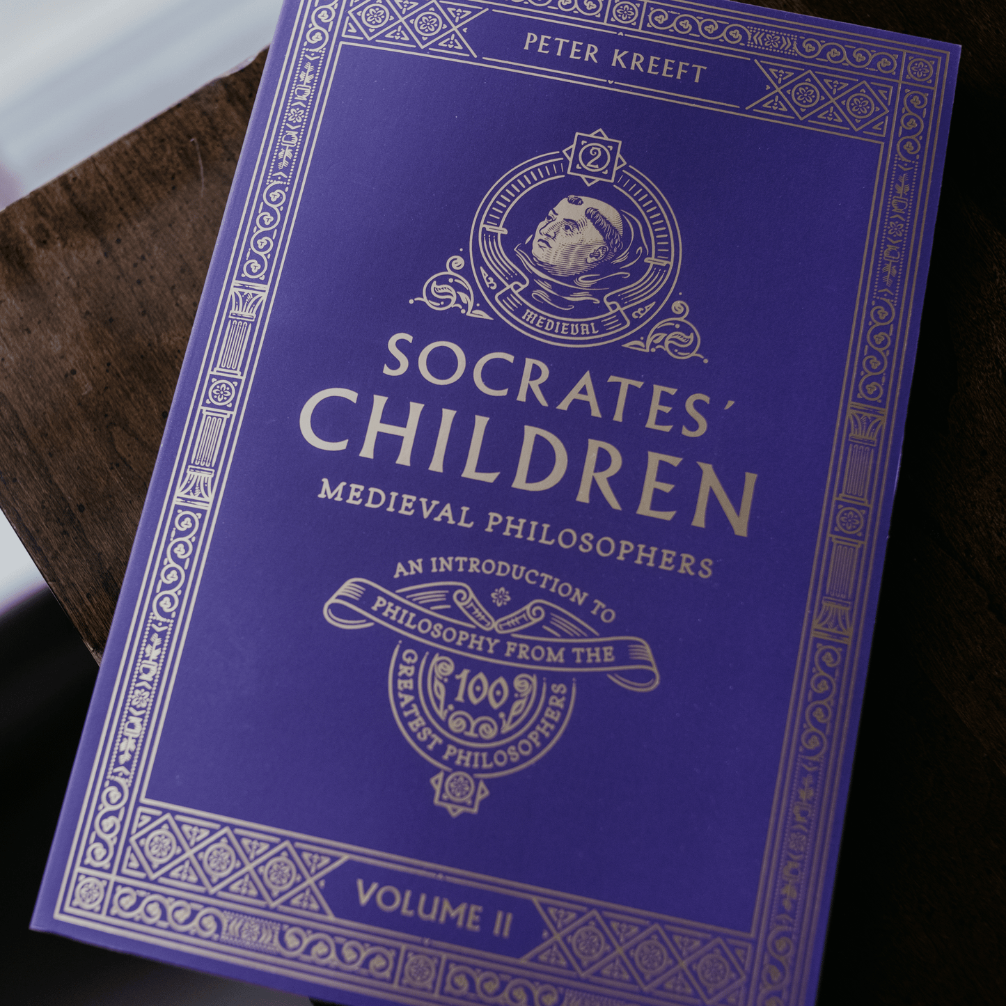 Socrates' Children Volume II: Medieval Philosophers book cover in royal purple with gold embossed text and design, by Peter Kreeft, part of Socrates Children book series, philosophy book, overview of philosophers throughout history, paperback 9781685780111