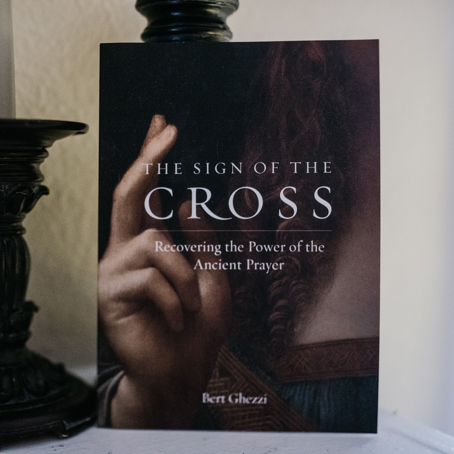 The Sign of the Cross book cover featuring a close-up of a hand making the sign of the cross, emphasizing spiritual growth and ancient prayer by Bert Ghezzi, paperback 9781685780326