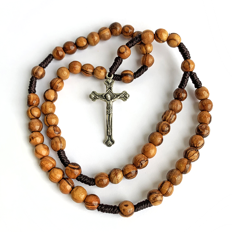 The Word on Fire Rosary featuring polished wooden beads with natural grain and a detailed metal crucifix, designed for Catholic spiritual growth and prayer.