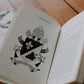 Inside pages of I Am A Son of Saint Augustine book showing illustration of Pope Leo XIV's coat of arms and papal motto, paperback 9781685783198