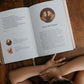 A child reading "The Story of All Stories" open to a page titled The Last Supper, featuring gentle illustrations and text about Catholic themes, by Emily Stimpson Chapman, illustrated Catholic children's bible, suitable for children ages 7-13, hardcover 9781685782214 