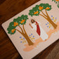 Illustration of Jesus standing between two trees with orange fruit and purple flowers, part of Magnificat Canticle of Mary, illustrated by Tricia Dugat, board book 9781685781521
