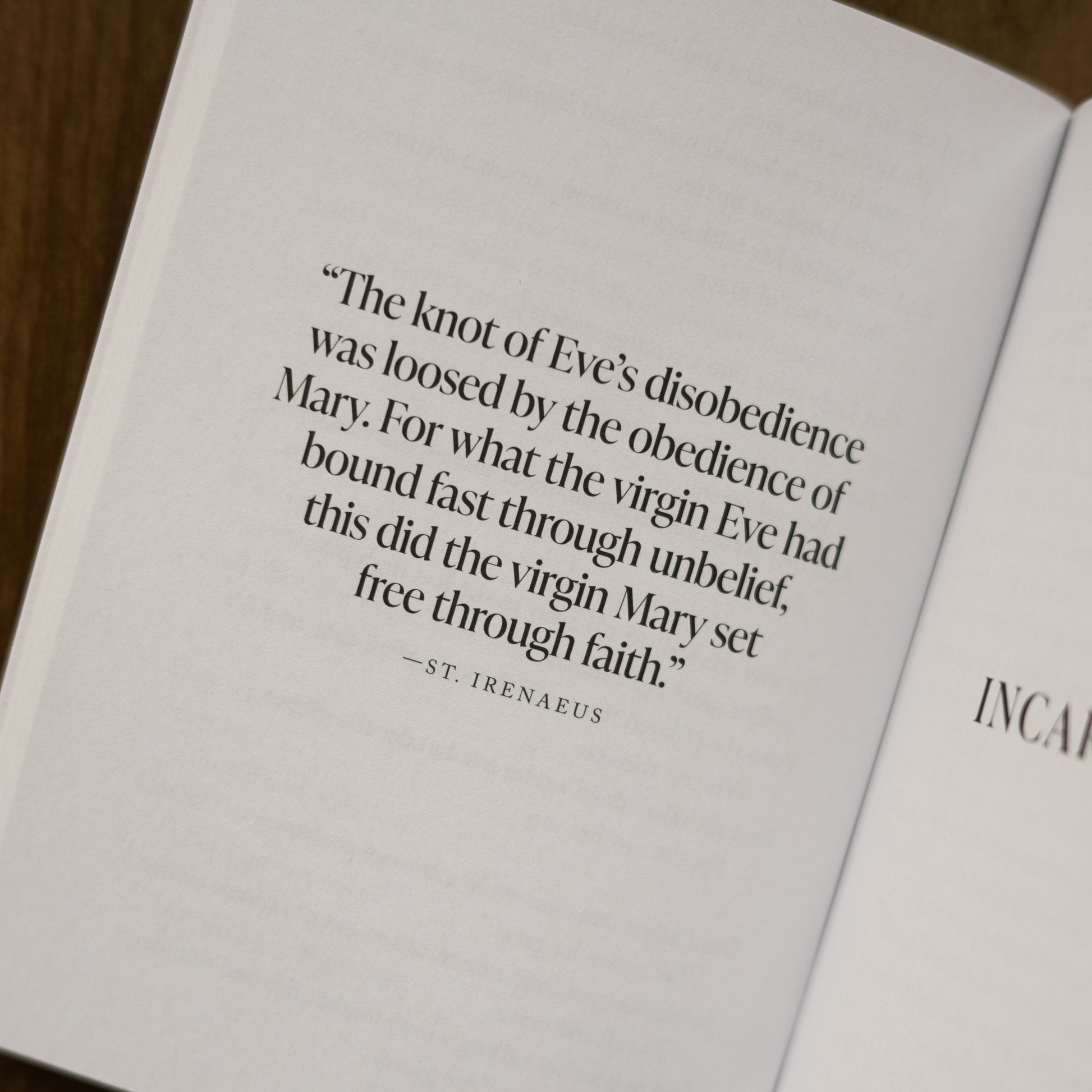 Open book page featuring a quote by St. Irenaeus about Eve and Mary, part of the Catholic spiritual growth book "The Word Became Flesh", contributors include Matthew Becklo and Bishop Robert Barron, prayer book for Advent, Advent reflection books for Catholics, paperback 9781685780210