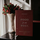 The hardcover book "Food for the Soul - Cycle C" by Peter Kreeft displayed next to a vase of red flowers, book for spiritual growth and Catholic reflection, by Peter Kreeft, reflections on the daily Mass readings